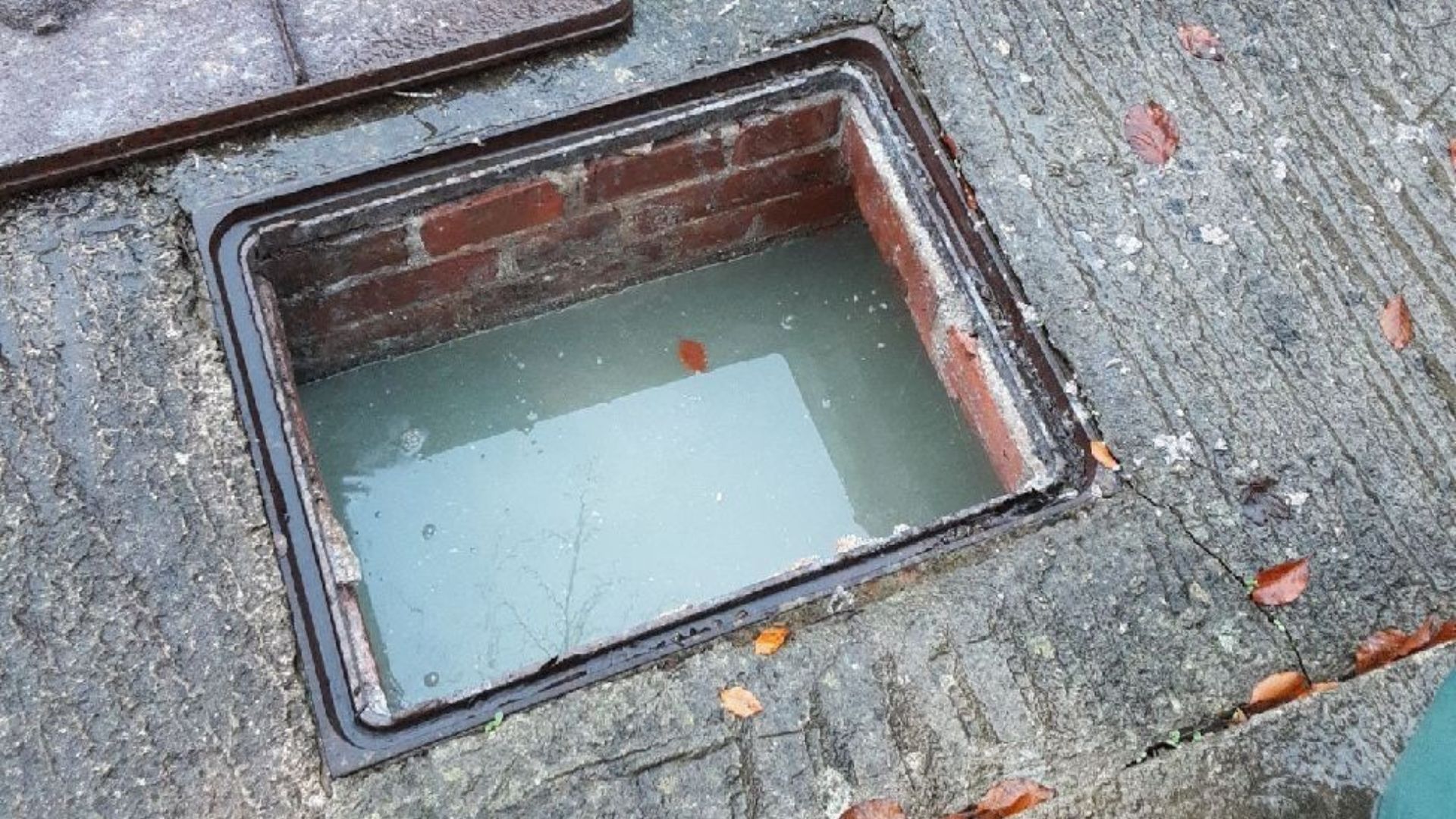 Open interceptor chamber showing accumulated water and waste before cleaning