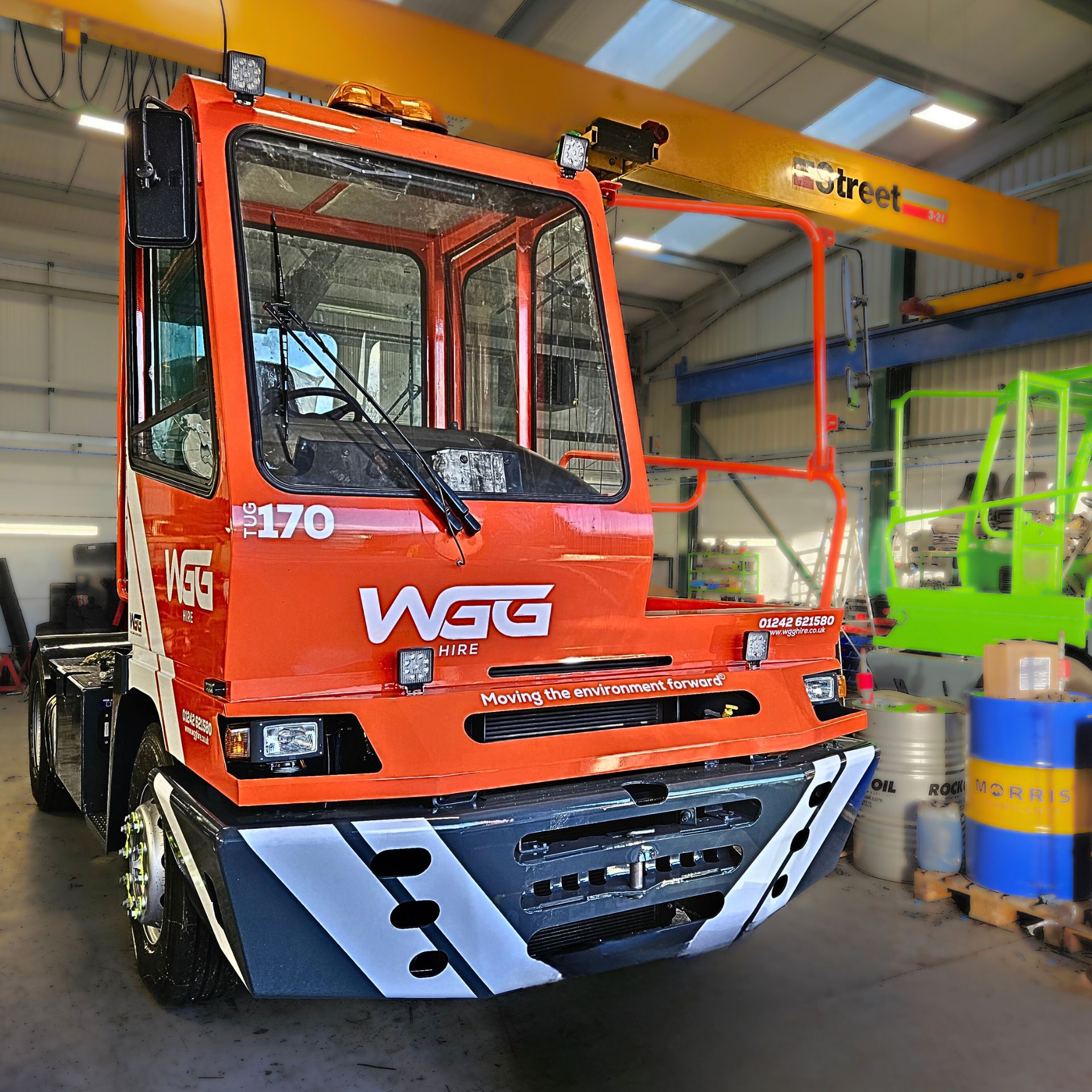 A front view of an orange tug vehicle in a garage