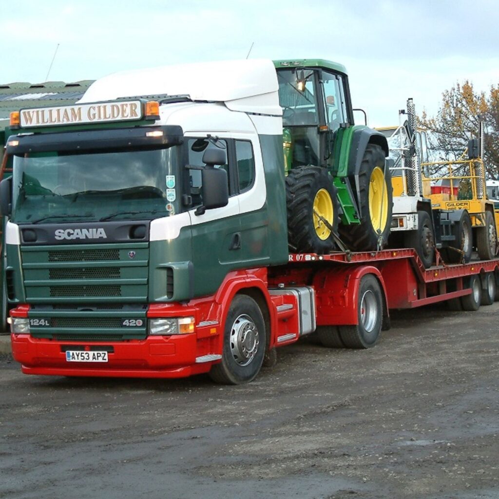 A tractor being transported via lorry