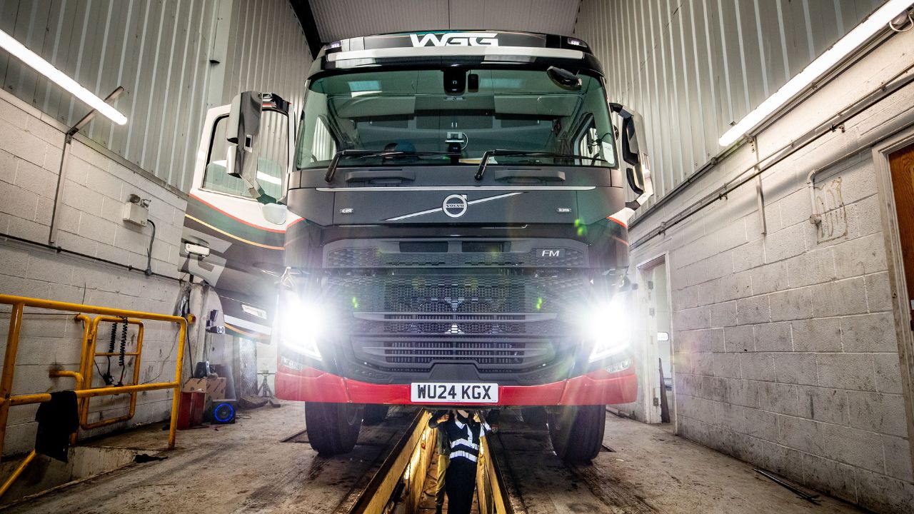 A lorry with headlights on in a garage