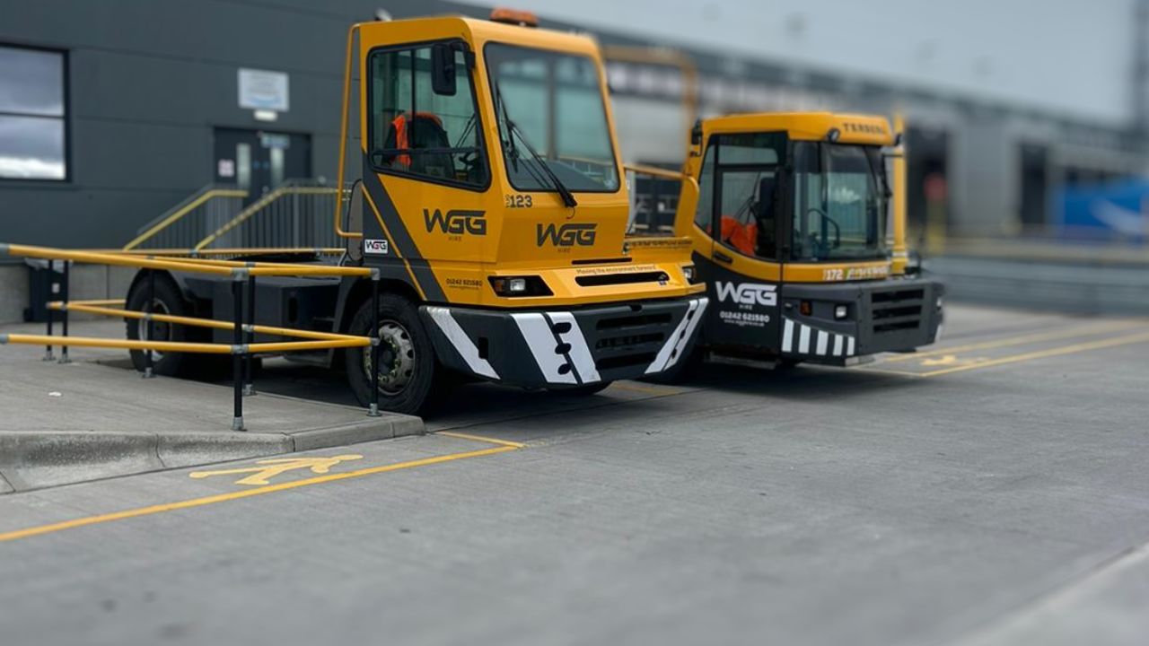 Two yellow lorry tugs at a warehouse